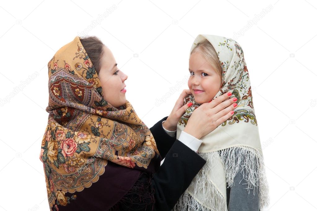 mother adjusts  shawl on the head daughter