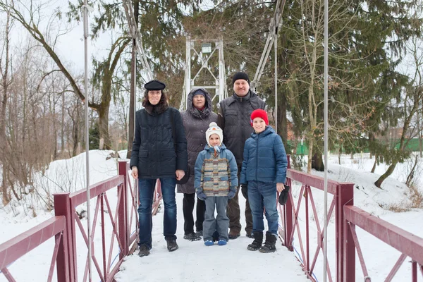 Família de pé na ponte no parque de inverno — Fotografia de Stock