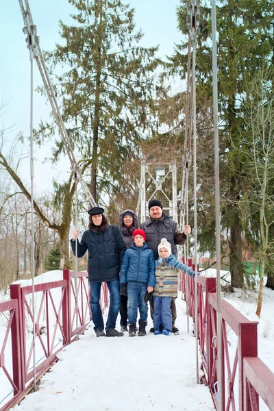 Famiglia in piedi sul ponte nel parco invernale — Foto Stock