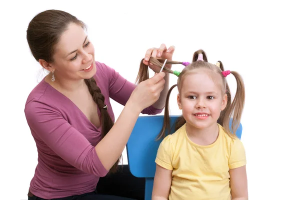 Mamma att göra hennes dotter frisyr — Stockfoto