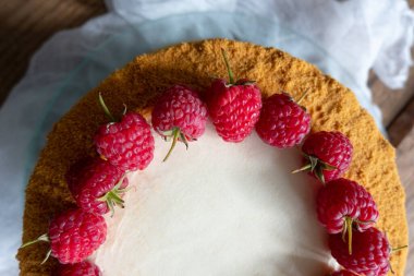  Ahşap bir arka planda ahududuyla süslenmiş Rus ballı keki.