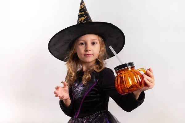 Niña en traje de halloween sosteniendo una calabaza en sus manos sobre un fondo blanco —  Fotos de Stock