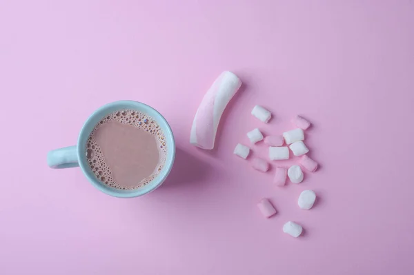 Caneca de cor azul com cacau e marshmallows branco-rosa em um fundo rosa — Fotografia de Stock