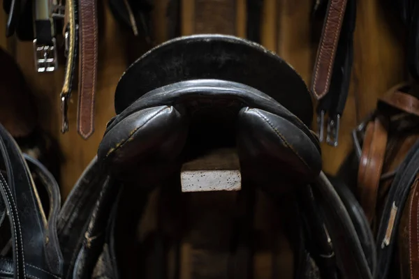 horse leather saddle hanging on a wooden wall