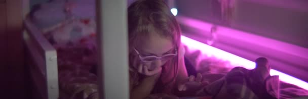 Dziewczynka z tabletką na łóżku anamorficzny 2x — Wideo stockowe