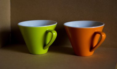 Kahverengi karton zemin ile turuncu ve yeşil fincan fincan