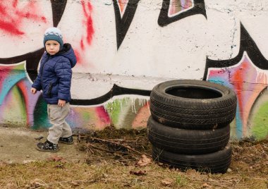 Çocuk, eski lastikler ve graffity