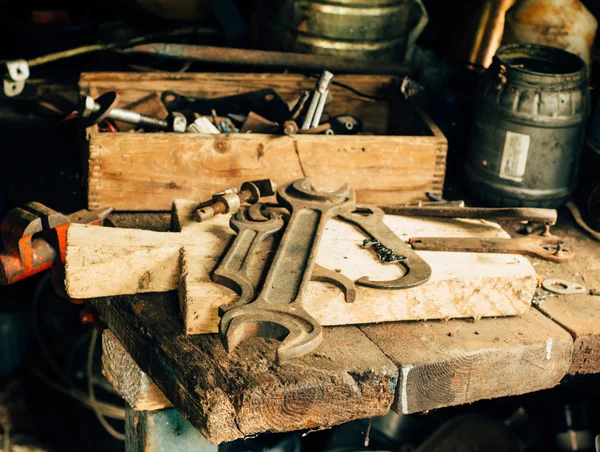 Chave grande e algumas outras ferramentas na garagem na mesa — Fotografia de Stock