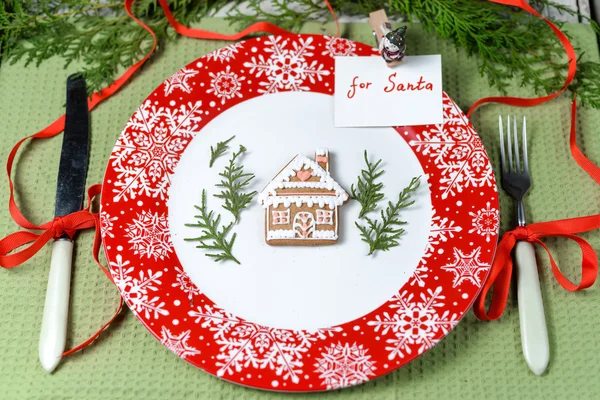 Рождественские украшения для стола с красным блюдом и столовыми приборами — стоковое фото