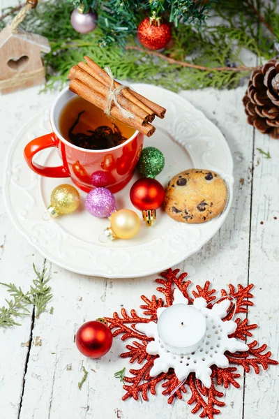 Christmas celebration tea time with cinnamon, cookie and baubles with Christmas tree background — Stock Photo, Image