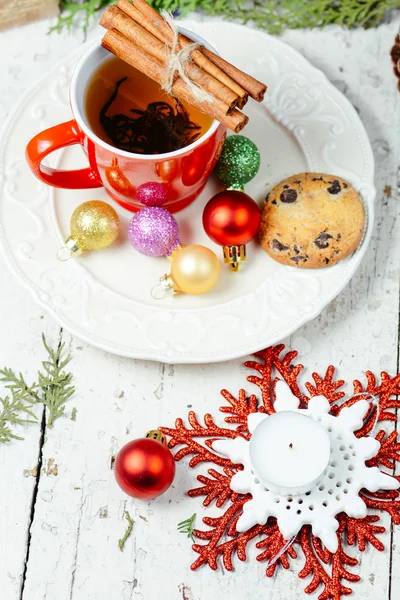 Christmas celebration tea time with cinnamon, cookie and baubles with Christmas tree background — Stock Photo, Image