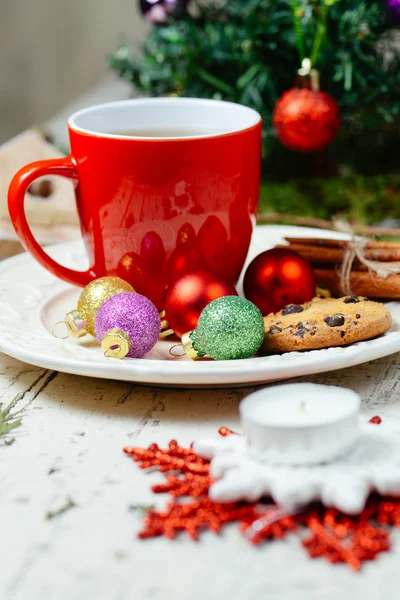 Christmas celebration tea time with cinnamon, cookie and baubles with Christmas tree background — Stock Photo, Image