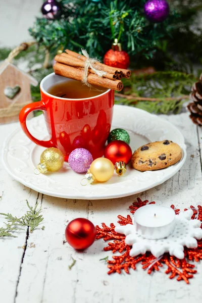 Christmas celebration tea time with cinnamon, cookie and baubles with Christmas tree background — Stock Photo, Image