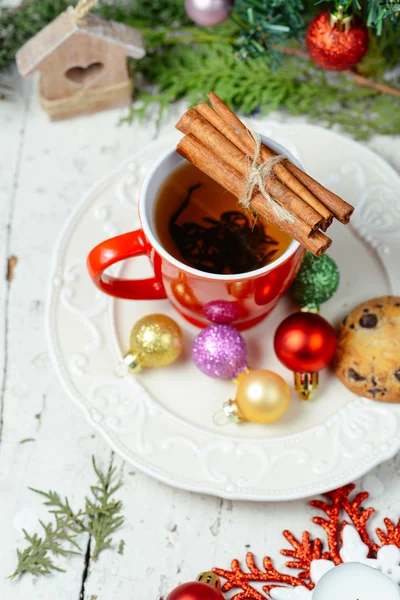 Christmas celebration tea time with cinnamon, cookie and baubles with Christmas tree background — Stock Photo, Image