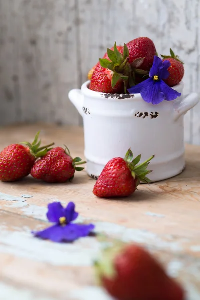 Aardbeien in een witte kom met houten achtergrond — Stockfoto