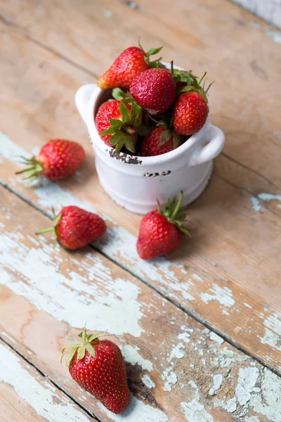 Strawberries in a white bowl with wooden background — Stock Photo, Image