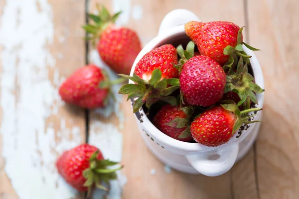 Strawberries in a white bowl with wooden background — Stock Photo, Image