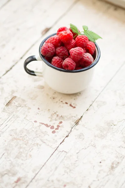 Raspberries in an enamel cup — Stock Photo, Image