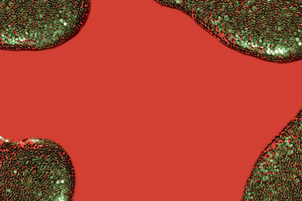 Líquido transparente com glitter verde derramando sobre um fundo vermelho coral — Fotografia de Stock