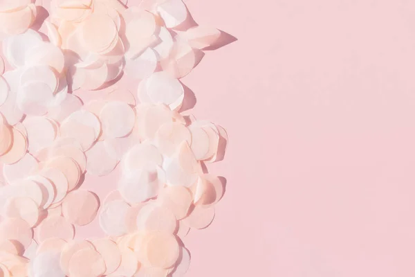 Branco rosa e papel confetti em um fundo rosa pastel — Fotografia de Stock