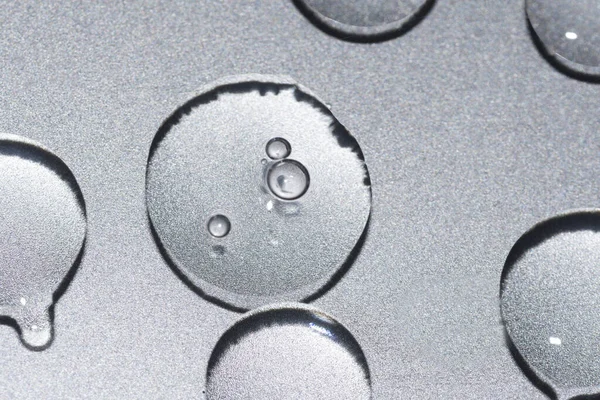 金属銀の背景に透明なゲル状のテクスチャ液滴 — ストック写真