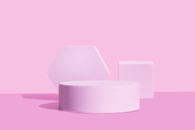 Geometrik şekilli pembe podyum. Arka plan tek renkli.