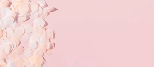 Branco rosa e papel confetti em um fundo rosa pastel — Fotografia de Stock