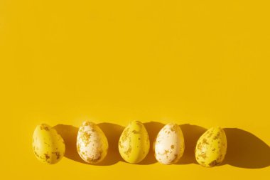 Sarı ve beyaz Paskalya yumurtaları. Grafik gölgeli altınla boyanmış.