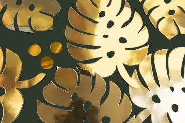 Altın kağıt canavarı, koyu yeşil bir arka planda sınırdan ayrılıyor.