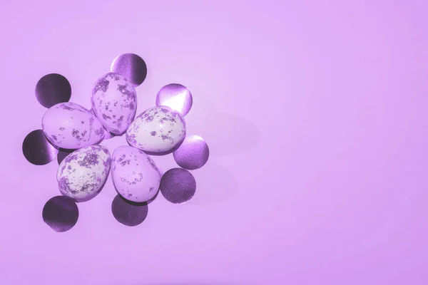 Pastel arka planda yuvarlak konfetili mor ve beyaz Paskalya yumurtaları. — Stok fotoğraf