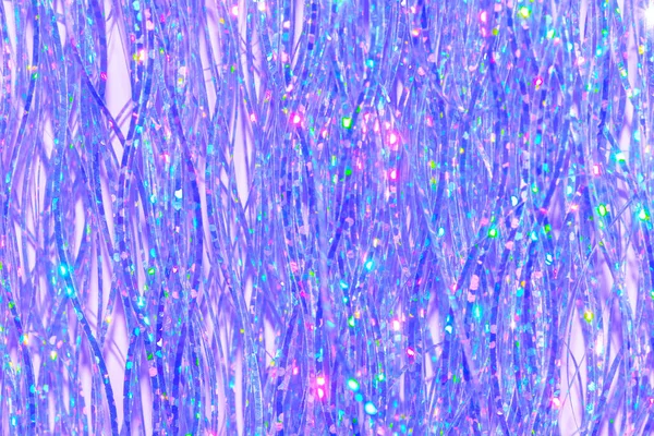 紫の背景のお祝いホログラフィックティンセルフリンジの詳細 — ストック写真