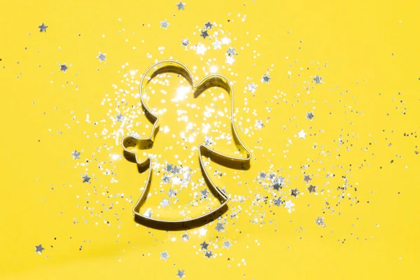 Zilver Kerst thema cookie cutter op een heldere gele achtergrond — Stockfoto