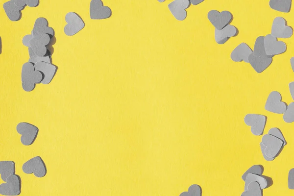 Coração forma confete em um fundo amarelo — Fotografia de Stock