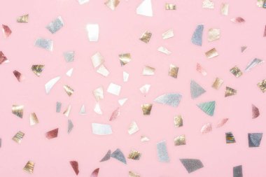 Pastel pembe arka planda parlak metalik konfeti