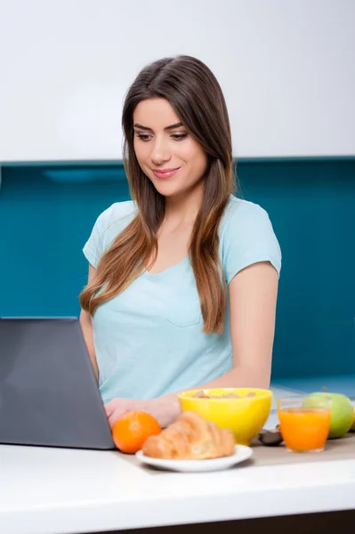 Moderne vrouw die thuis ontbijt neemt en haar post controleert, of online winkelt — Stockfoto