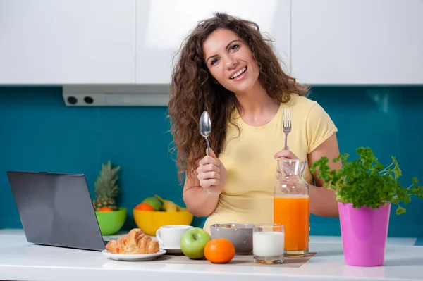 Girl at the kitchen table taking  breakfast. — Stock Photo, Image