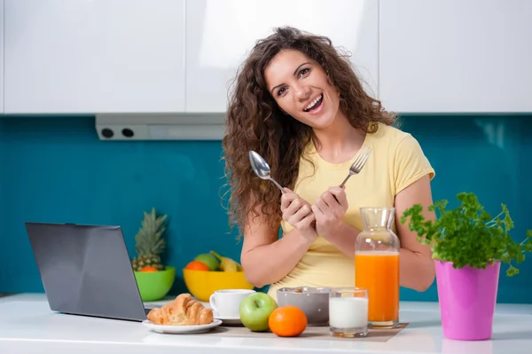 Flicka vid köksbordet tar frukost. — Stockfoto