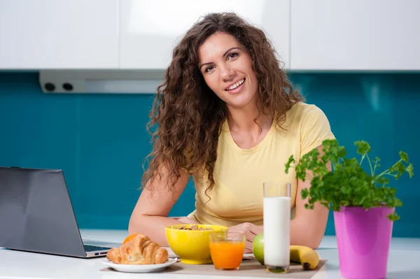 Kvinna äter frukost och komma ikapp på hennes sociala medier — Stockfoto