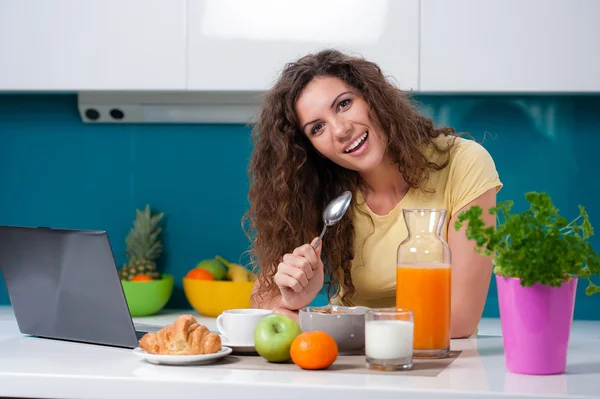 Girl at the kitchen table taking  breakfast. — Stock Photo, Image