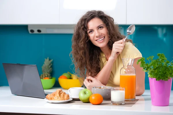 Flicka vid köksbordet tar frukost. — Stockfoto