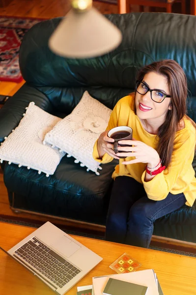 Meisje zittend op de Bank een kopje thee drinken — Stockfoto