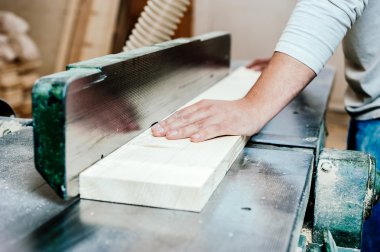 Carpenter working cutting some boards, he is wearing safety glasses and hearing protection