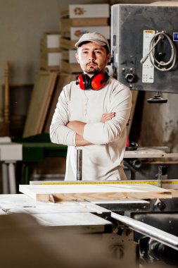 Carpenter working on wood machine in factory