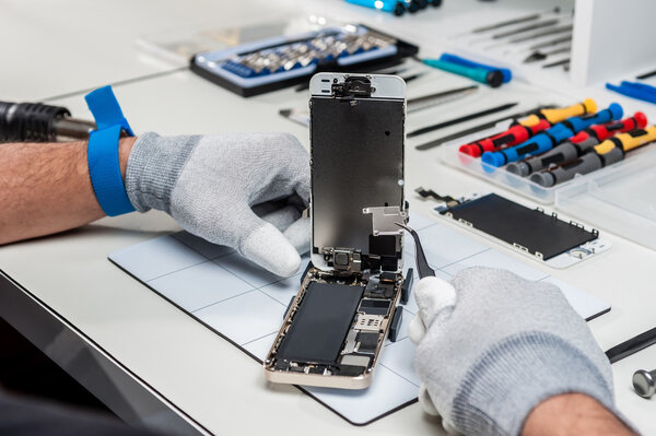 Фотографии крупным планом, показывающие процесс ремонта мобильных телефонов