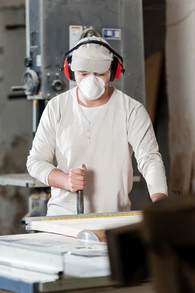 Carpenter working on wood machine in factory — стокове фото