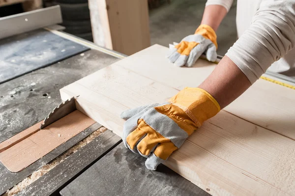 Tischler arbeitet mit industriellem Werkzeug in Holzfabrik, Kreissäge mit Holzbrett — Stockfoto