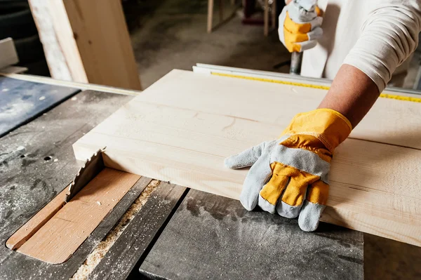 Tischler arbeitet mit industriellem Werkzeug in Holzfabrik, Kreissäge mit Holzbrett — Stockfoto