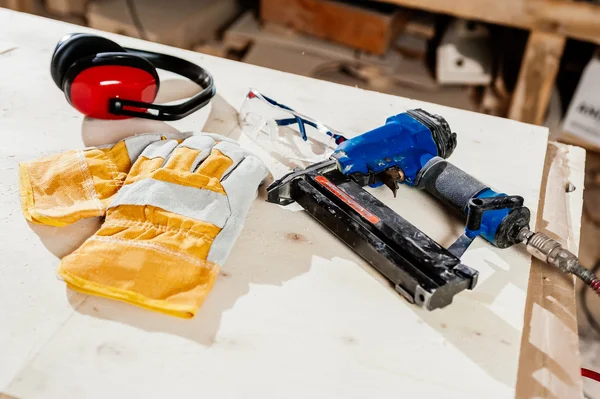 Carpenter tools and protective wear on plywood — Zdjęcie stockowe