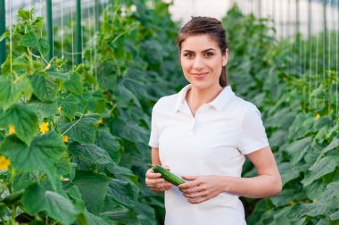 Happy Young woman holding cucumbers