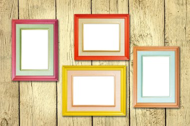 Four multicolored photo frames on the retro wood wall